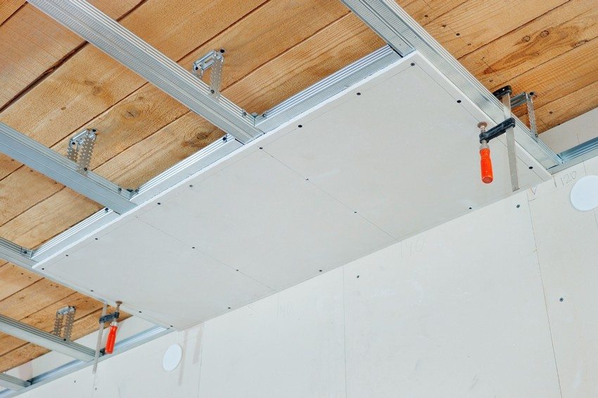 Монтаж гипсокартонного потолка в гостиной деревянного дома